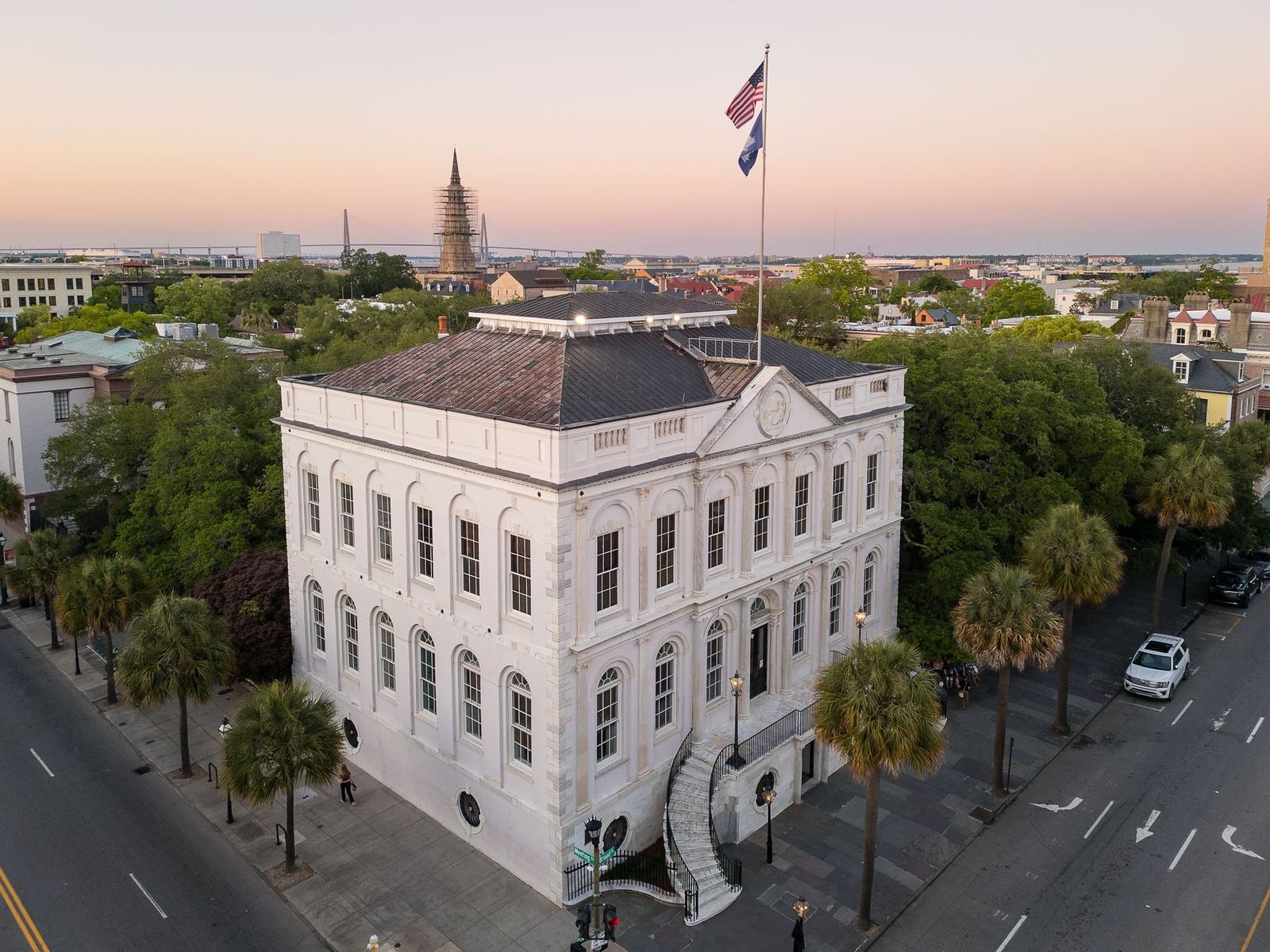 Charleston City Hall at sunset with palmettos along the street
