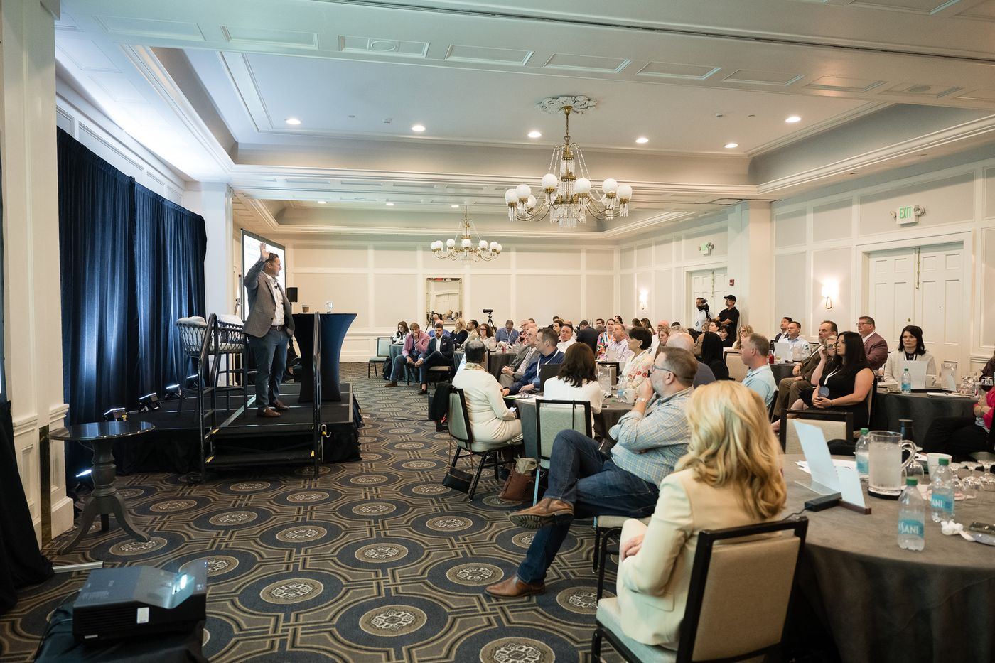A speaker addressing the room from the stage