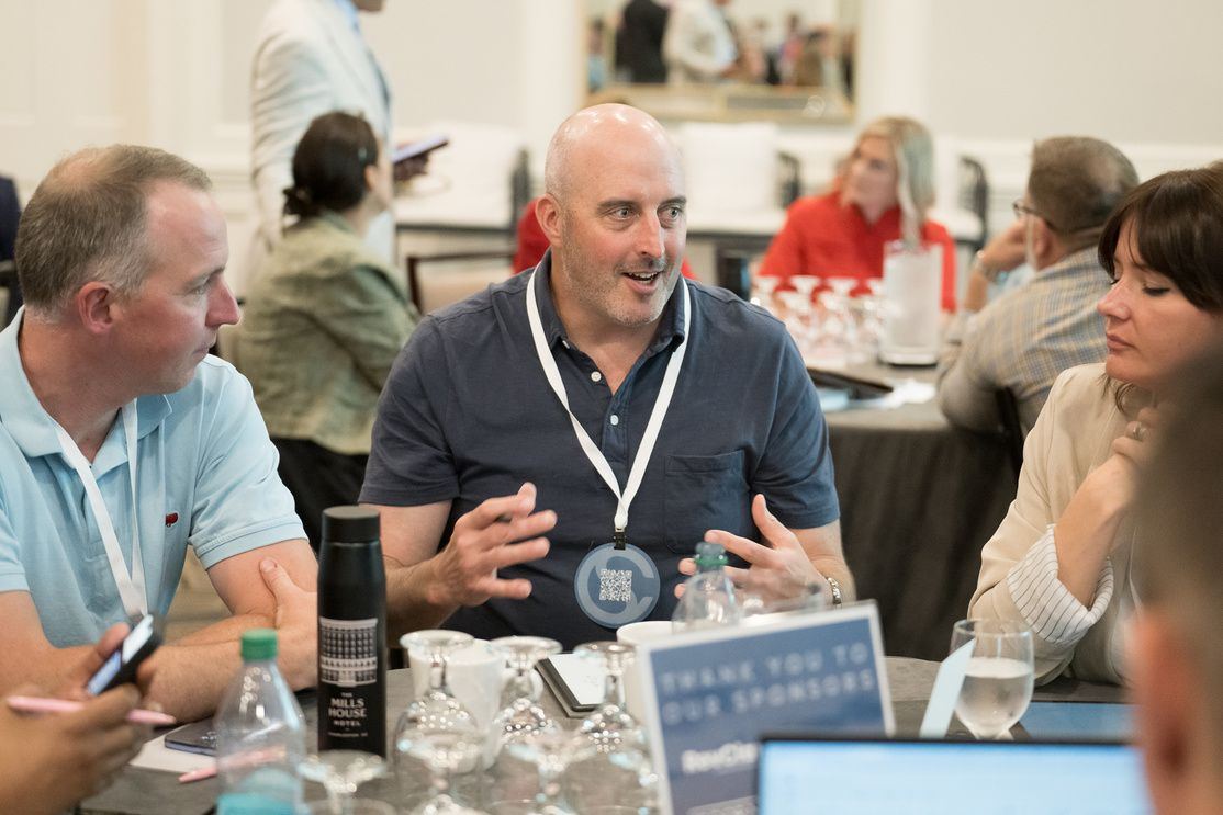 Attendees in conversation at a summit table